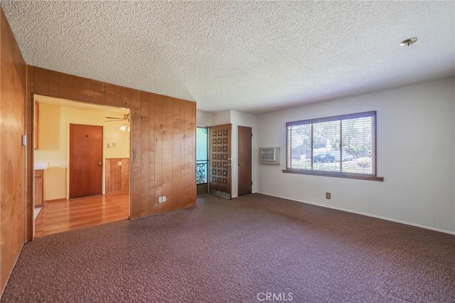 2001 W Jan Way, Santa Ana, CA 92704 - unfurnished bedroom featuring a textured ceiling, an AC wall unit, wood walls, and carpet