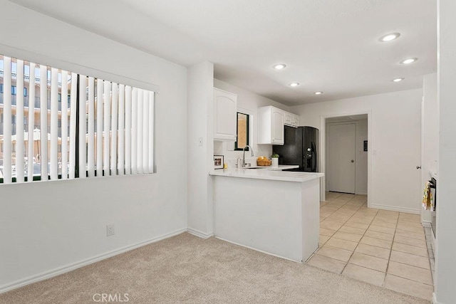 12400 Montecito Rd Unit 222, Seal Beach, CA 90740 - kitchen with black fridge, white cabinetry, recessed lighting, light countertops, and a peninsula