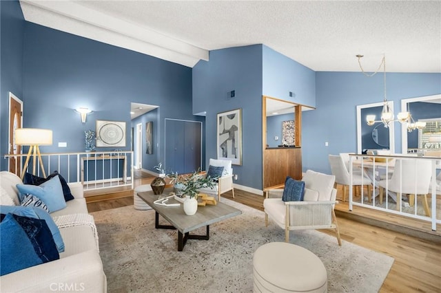 26017 Redbluff Dr, Calabasas, CA 91302 - living area with a chandelier, high vaulted ceiling, wood finished floors, and a textured ceiling
