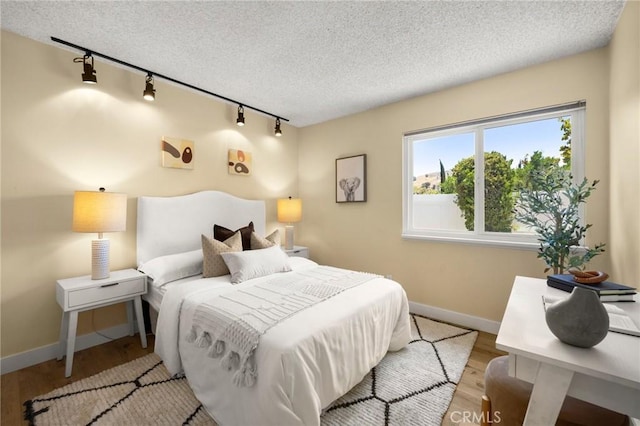 26017 Redbluff Dr, Calabasas, CA 91302 - bedroom featuring track lighting, a textured ceiling, and wood finished floors
