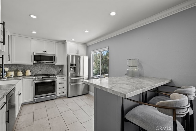 9778 Via Roma, Burbank, CA 91504 - kitchen with stainless steel appliances, ornamental molding, backsplash, white cabinets, and recessed lighting