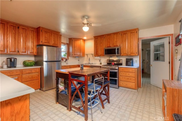 217 N Plumas St, Willows, CA 95988 - kitchen featuring stainless steel appliances, light flooring, light countertops, ceiling fan, and brown cabinetry