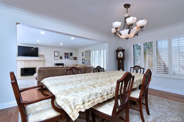 17000 Addison St, Encino, CA 91316 - dining space with a chandelier, recessed lighting, a glass covered fireplace, crown molding, and wood finished floors