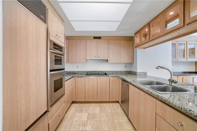 850 E Ocean Blvd Unit 1604, Long Beach, CA 90802 - kitchen with light brown cabinetry, stainless steel appliances, glass insert cabinets, and light stone counters