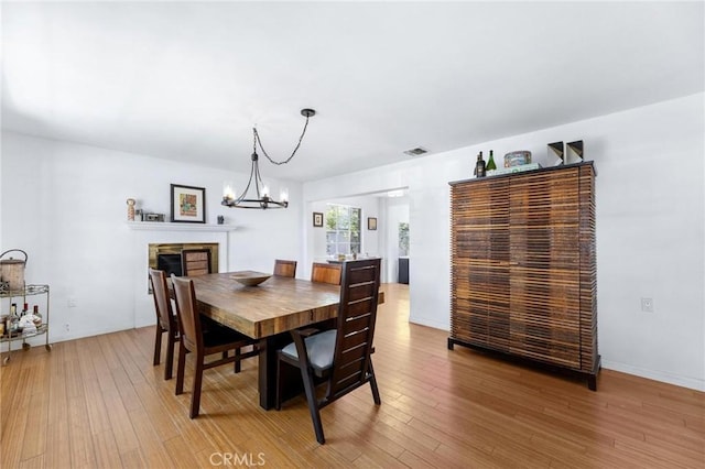 1544 3rd St, Manhattan Beach, CA 90266 - dining area with a chandelier, light wood-style floors, and a fireplace