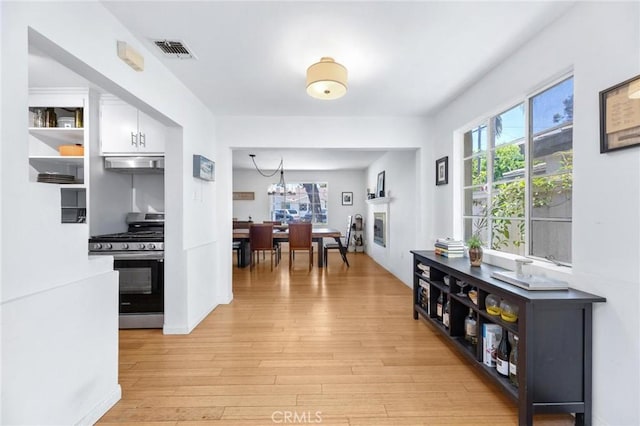 1544 3rd St, Manhattan Beach, CA 90266 - hallway with light wood-style floors and a chandelier