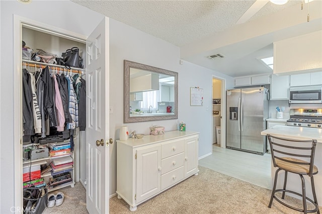 43840 Bobby Jones Dr Unit 22, Lancaster, CA 93536 - kitchen with stainless steel appliances, light carpet, light countertops, and a textured ceiling