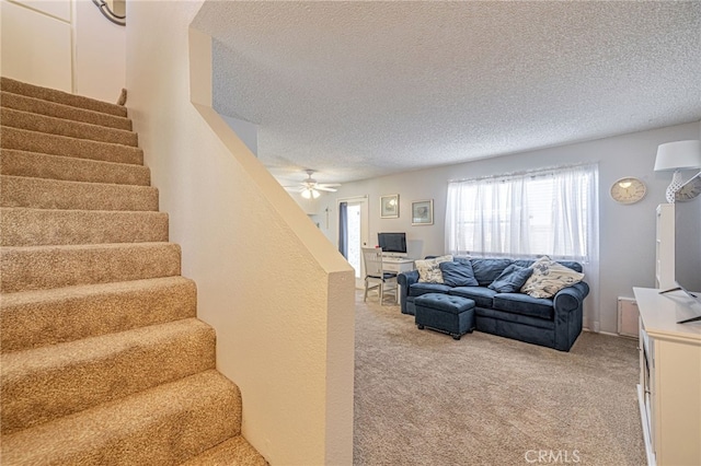 43840 Bobby Jones Dr Unit 22, Lancaster, CA 93536 - living area featuring a textured ceiling, light colored carpet, stairway, and a ceiling fan