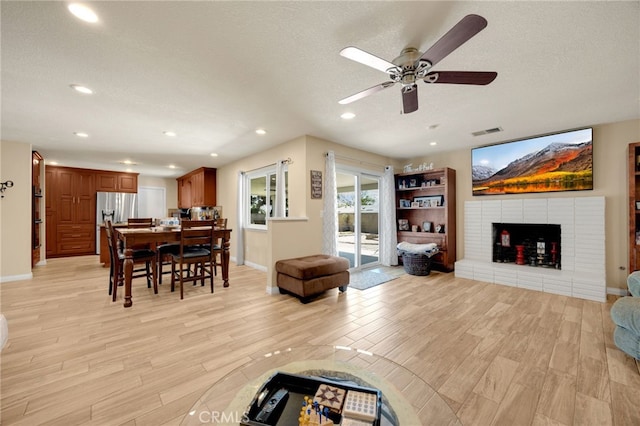 1219 N Van Buren St, Placentia, CA 92870 - living area with light wood finished floors, a ceiling fan, a fireplace, recessed lighting, and a textured ceiling