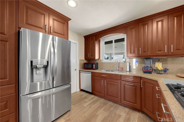 1219 N Van Buren St, Placentia, CA 92870 - kitchen with appliances with stainless steel finishes, brown cabinets, tasteful backsplash, and light wood-style floors