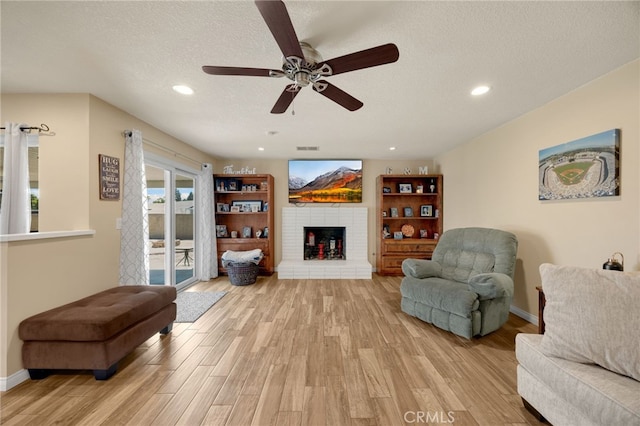 1219 N Van Buren St, Placentia, CA 92870 - living area featuring light wood-style floors, ceiling fan, recessed lighting, a textured ceiling, and a brick fireplace