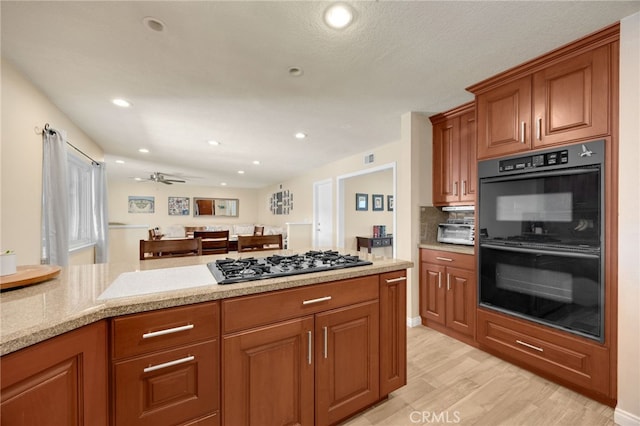 1219 N Van Buren St, Placentia, CA 92870 - kitchen with stainless steel gas stovetop, light wood-style floors, brown cabinets, recessed lighting, and a ceiling fan
