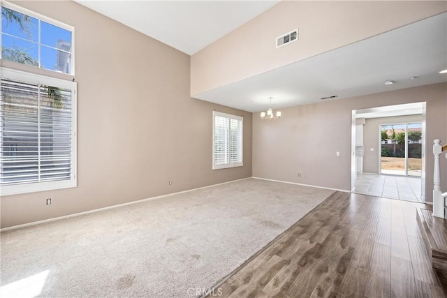 15353 Isabel Ln, Fontana, CA 92336 - empty room with a chandelier, wood finished floors, a towering ceiling, and carpet floors