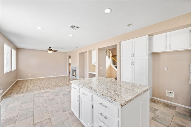15353 Isabel Ln, Fontana, CA 92336 - kitchen with ceiling fan, white cabinets, light stone counters, a kitchen island, and recessed lighting