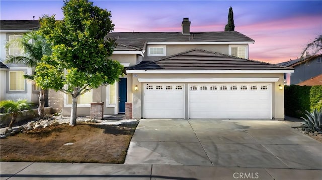 15353 Isabel Ln, Fontana, CA 92336 - traditional-style home with a garage, concrete driveway, stucco siding, and a chimney