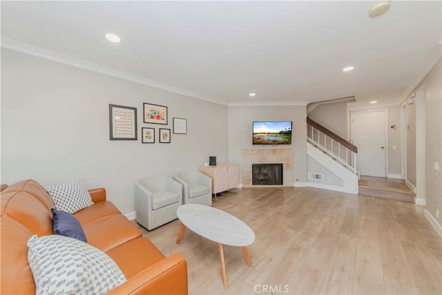 2323 S Cutty Way Unit 58, Anaheim, CA 92802 - living room with stairway, crown molding, light wood finished floors, recessed lighting, and a tile fireplace