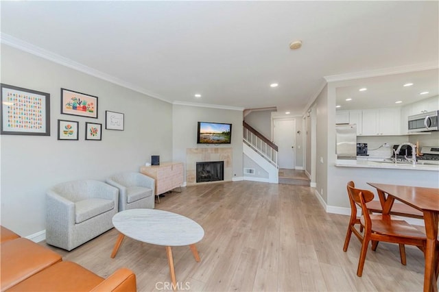 2323 S Cutty Way Unit 58, Anaheim, CA 92802 - living area with crown molding, recessed lighting, light wood-style flooring, a fireplace, and stairway