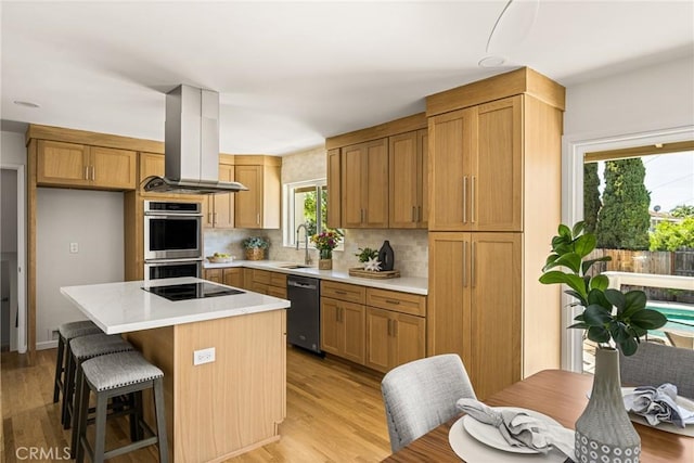 17542 Rainier Dr, North Tustin, CA 92705 - kitchen with dishwashing machine, ventilation hood, double oven, black electric cooktop, and light countertops