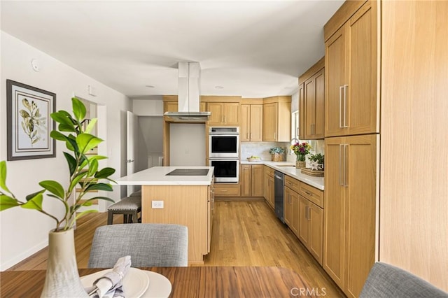 17542 Rainier Dr, North Tustin, CA 92705 - kitchen featuring stainless steel appliances, ventilation hood, a kitchen island, light wood-style flooring, and light countertops