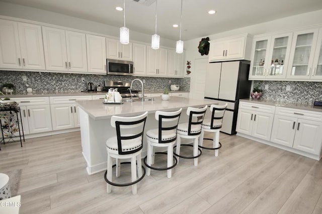 1622 Trailview Dr, Beaumont, CA 92223 - kitchen with appliances with stainless steel finishes, tasteful backsplash, white cabinetry, recessed lighting, and light countertops