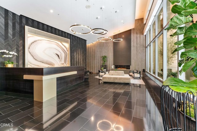1155 S Grand Ave Unit 1510, Los Angeles, CA 90015 - welcome area with wallpapered walls, a towering ceiling, and a warm lit fireplace