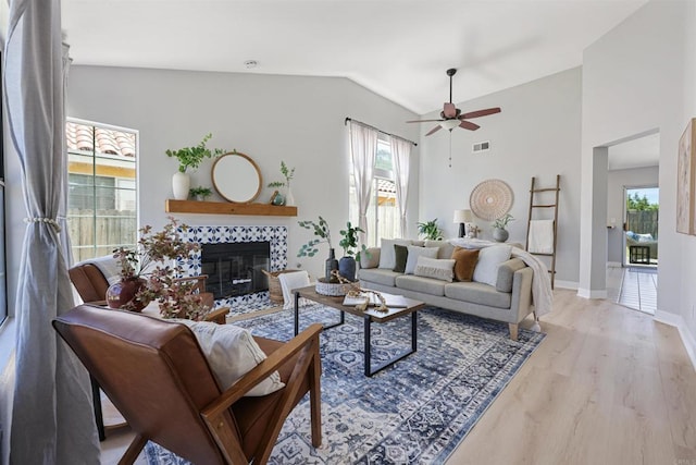 5452 Gooseberry Way, Oceanside, CA 92057 - living room featuring ceiling fan, vaulted ceiling, a tiled fireplace, and wood finished floors