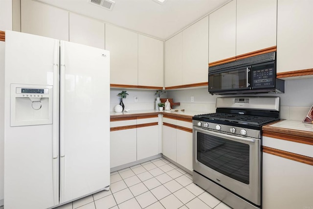 5452 Gooseberry Way, Oceanside, CA 92057 - kitchen featuring white fridge with ice dispenser, stainless steel gas range, black microwave, white cabinetry, and light tile patterned floors