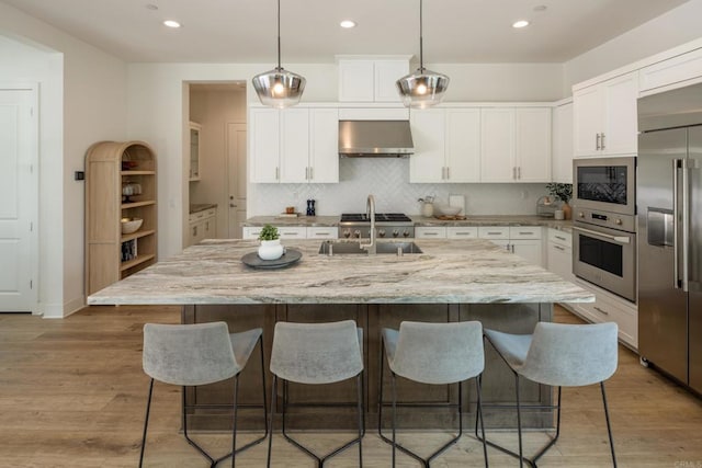 744 Adelaide Cir, Encinitas, CA 92024 - kitchen featuring built in appliances, range hood, backsplash, a kitchen breakfast bar, and white cabinets