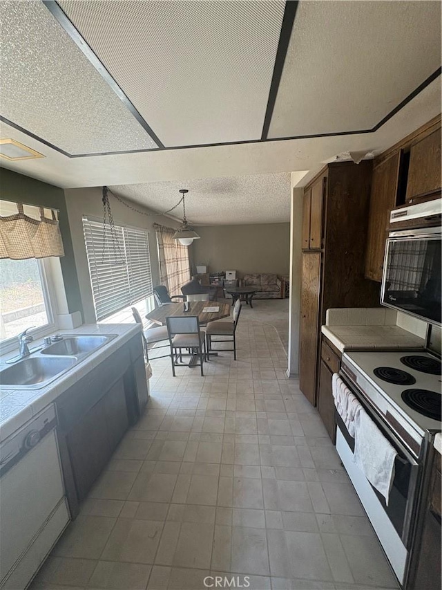 197 Limestone Rd, Claremont, CA 91711 - kitchen with white appliances, light countertops, a textured ceiling, dark brown cabinets, and pendant lighting