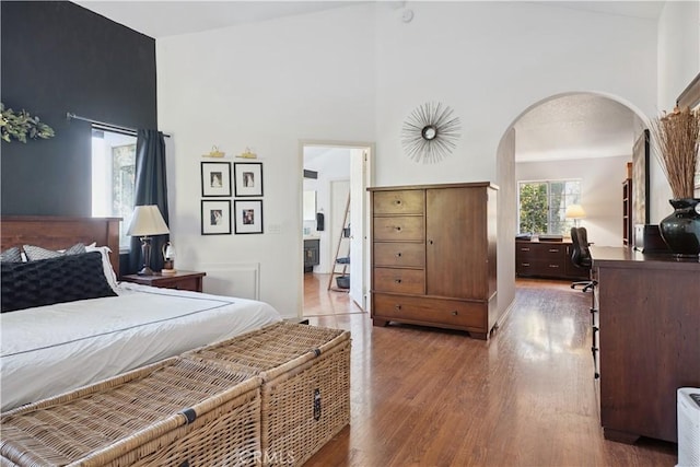 8042 Masefield Ct, West Hills, CA 91304 - bedroom featuring arched walkways, wood finished floors, an office area, and high vaulted ceiling