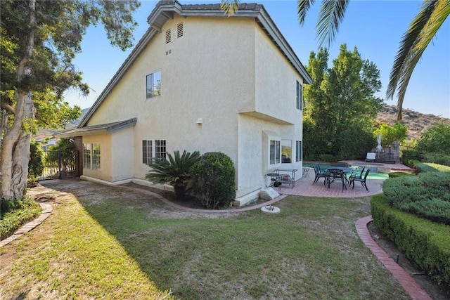 8042 Masefield Ct, West Hills, CA 91304 - rear view of house with stucco siding, a patio area, and a yard