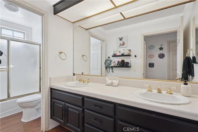 8042 Masefield Ct, West Hills, CA 91304 - bathroom with double vanity, wood finished floors, and bath / shower combo with glass door