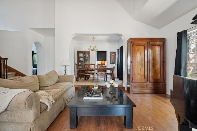 8042 Masefield Ct, West Hills, CA 91304 - living room with arched walkways, a chandelier, wood finished floors, stairway, and high vaulted ceiling