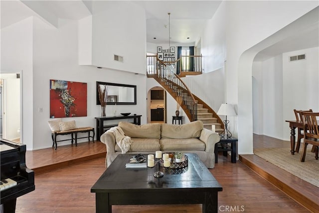8042 Masefield Ct, West Hills, CA 91304 - living room featuring a high ceiling, arched walkways, stairs, and wood finished floors