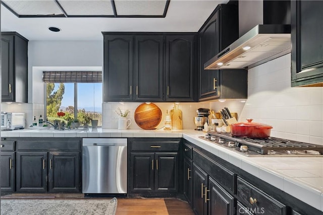 8042 Masefield Ct, West Hills, CA 91304 - kitchen featuring appliances with stainless steel finishes, wall chimney range hood, tile counters, and recessed lighting