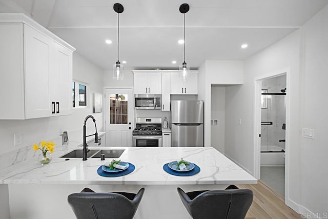 1254 13th St, Imperial Beach, CA 91932 - kitchen with appliances with stainless steel finishes, a peninsula, light wood finished floors, white cabinets, and light stone countertops