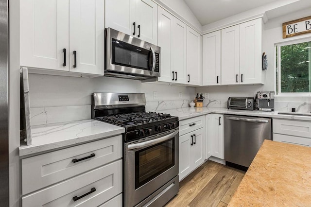 1254 13th St, Imperial Beach, CA 91932 - kitchen featuring stainless steel appliances, light wood-style flooring, white cabinetry, and light stone countertops