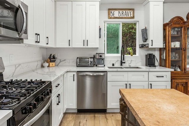 1254 13th St, Imperial Beach, CA 91932 - kitchen with appliances with stainless steel finishes, white cabinetry, light wood-style flooring, and light stone countertops