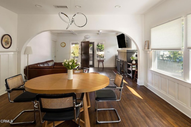 4207 Berenice Ave, Los Angeles, CA 90031 - dining area with wood finished floors, arched walkways, a fireplace, a decorative wall, and recessed lighting
