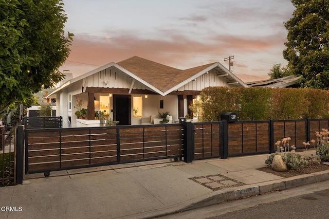 4207 Berenice Ave, Los Angeles, CA 90031 - view of front of home featuring a fenced front yard, a gate, a shingled roof, covered porch, and board and batten siding