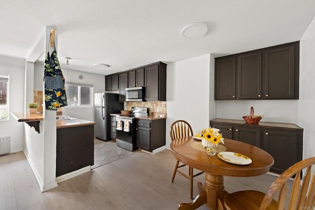 9860 Dale Ave Unit A8, Spring Valley, CA 91977 - kitchen with stainless steel appliances, dark brown cabinetry, backsplash, light wood-style flooring, and light countertops