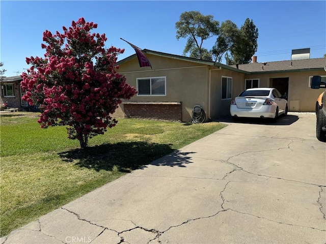 1602 W Dorothea Ave W, Visalia, CA 93277 - view of side of property with stucco siding, concrete driveway, and a yard