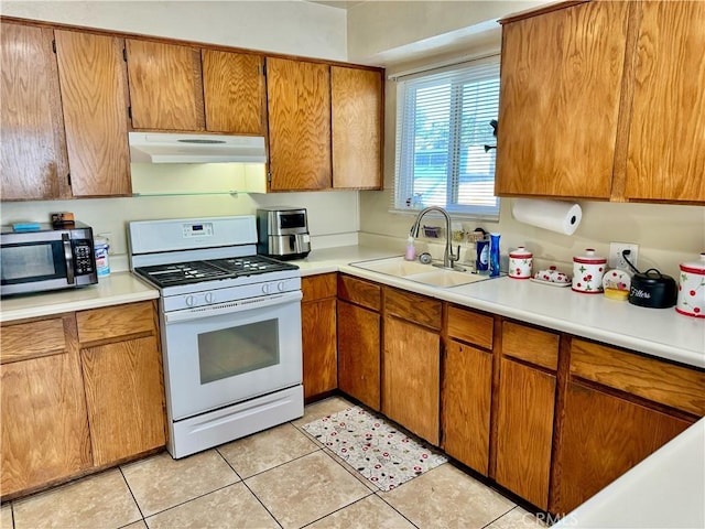 1602 W Dorothea Ave W, Visalia, CA 93277 - kitchen with gas range gas stove, under cabinet range hood, stainless steel microwave, light countertops, and brown cabinets