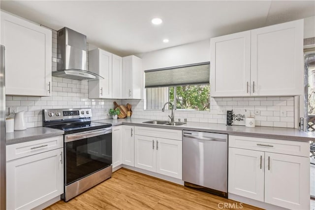 1124 S Citron Unit 85, Anaheim, CA 92805 - kitchen with stainless steel appliances, wall chimney range hood, white cabinets, tasteful backsplash, and recessed lighting