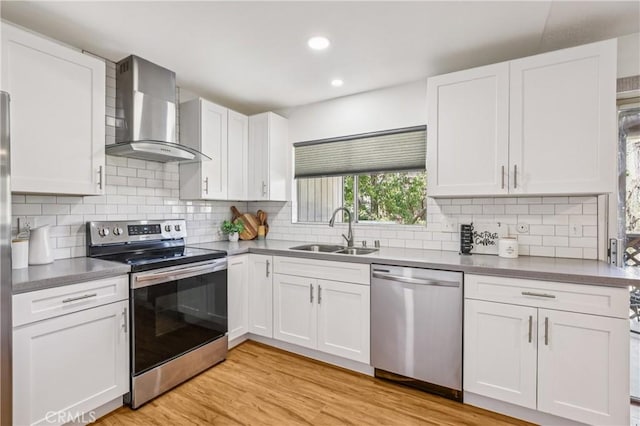 1124 S Citron Unit 85, Anaheim, CA 92805 - kitchen with stainless steel appliances, wall chimney exhaust hood, white cabinets, backsplash, and recessed lighting