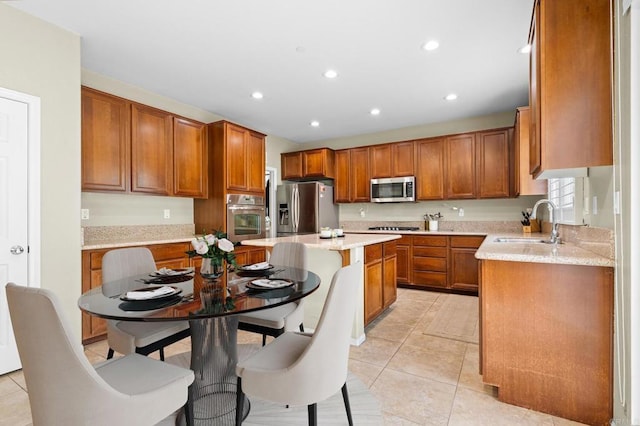 1789 Perrin Pl, Chula Vista, CA 91913 - kitchen with stainless steel appliances, light tile patterned flooring, brown cabinetry, a center island, and recessed lighting