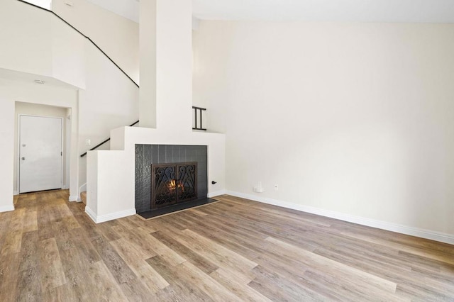 5149 Maplewood Cir, Oceanside, CA 92056 - unfurnished living room featuring wood finished floors, a warm lit fireplace, and stairs