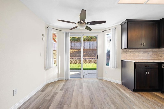 5149 Maplewood Cir, Oceanside, CA 92056 - kitchen with light wood-style flooring, light countertops, dark brown cabinetry, decorative backsplash, and ceiling fan