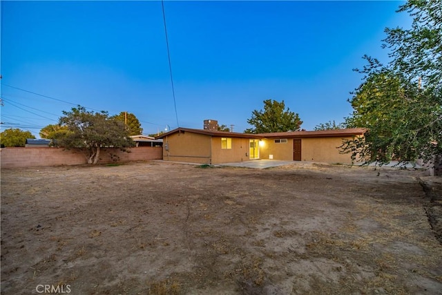 2017 W Newgrove St, Lancaster, CA 93536 - back of property with a patio, a chimney, and stucco siding