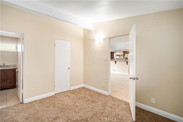 2017 W Newgrove St, Lancaster, CA 93536 - unfurnished bedroom with light colored carpet, light tile patterned floors, and connected bathroom